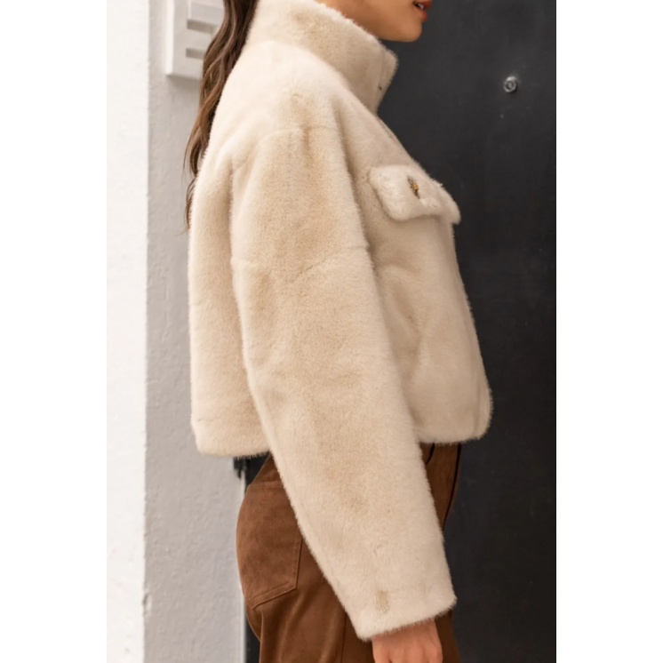 Manteau veste courte fausse fourrure beige claire, poches poitrines avec bijoux, fermeture éclaire et col montant.
